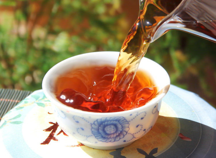 2022 Banzhang ripe Pu-erh tea liquor poured into a porcelain cup