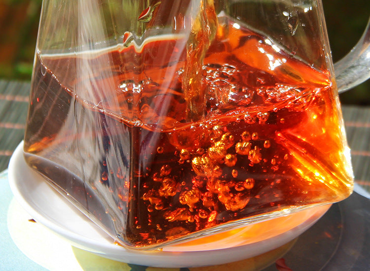 Ruby-red 2022 Banzhang ripe Pu-erh liquor in a glass fairness pitcher