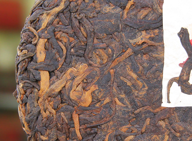 Close-up of golden tips and compressed leaf on 2022 Banzhang ripe Pu-erh cake