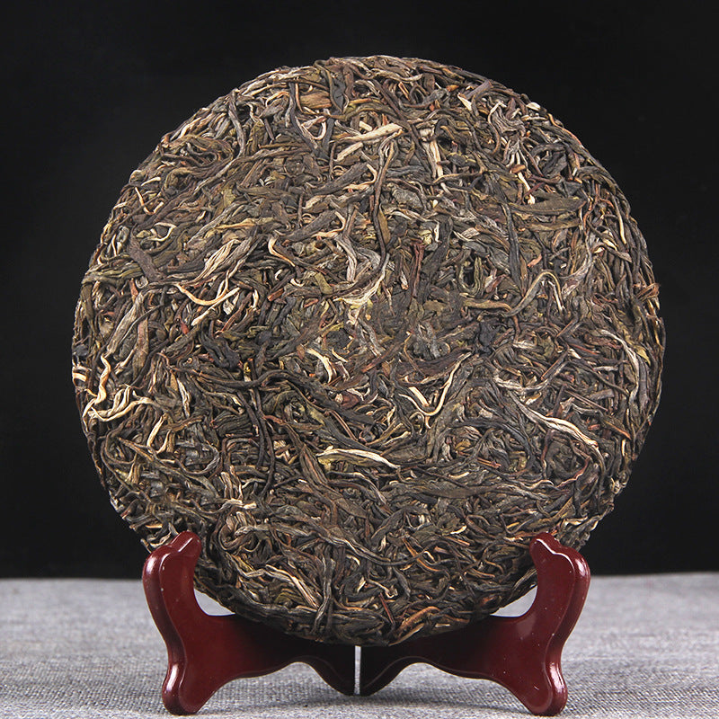 Unwrapped 2022 Pasha raw Pu-erh tea cake showing large-leaf material