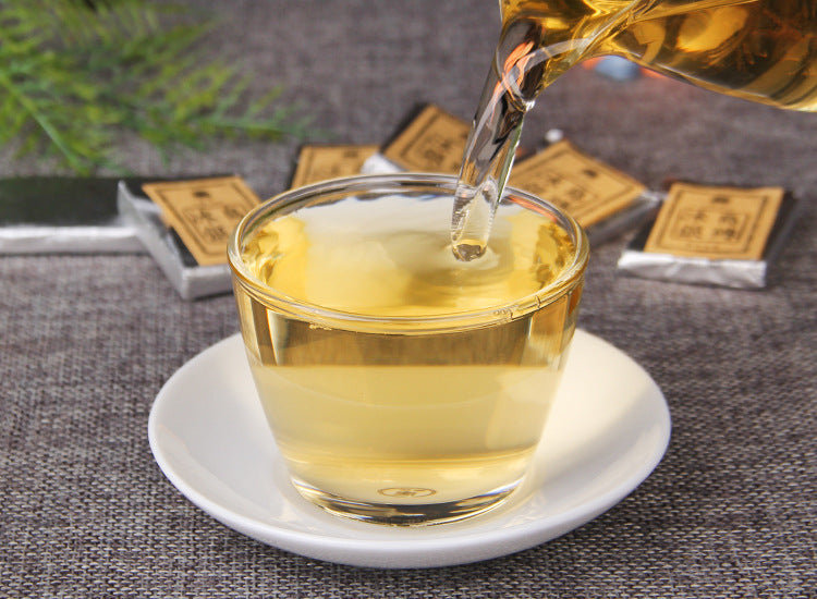 2023 Bingdao raw Pu-erh golden tea liquor being poured into a glass cup