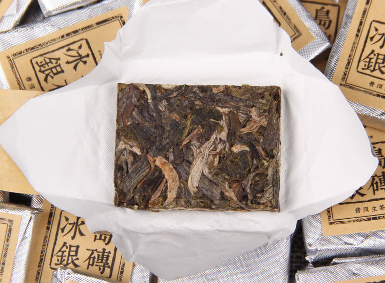 Unwrapped 2023 Bingdao raw Pu-erh mini square tea among silver wrappers
