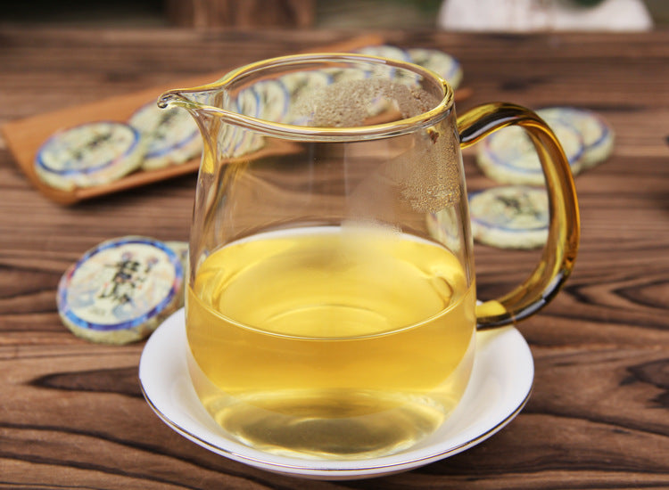 Brewed 2023 Xigui raw Pu-erh mini tea cake in glass pitcher golden liquor