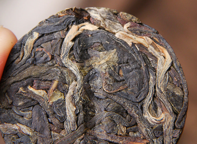 Compressed leaf close-up of 2023 Xigui raw Pu-erh mini tea cake 昔归生茶