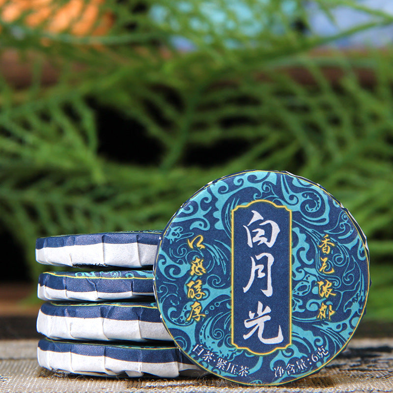 Unwrapped 2023 Yunnan Moonlight White mini tea cake showing leaf material