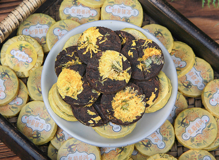 Bowl of chrysanthemum ripe Pu-erh mini cakes showing whole yellow chrysanthemum flowers on compressed tea