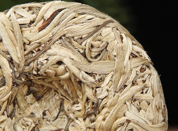 Baihao Yinzhen white tea cakes wrapped in bamboo tong