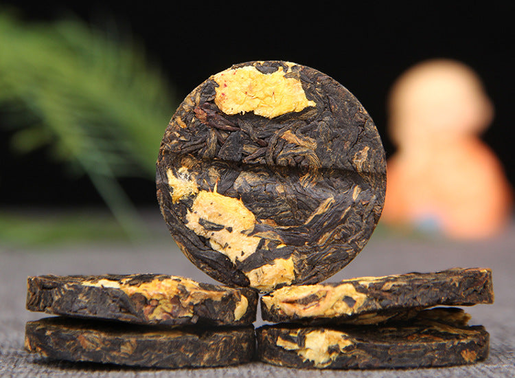 Unwrapped Cili chestnut rose Dianhong black tea mini cake showing fruit pieces