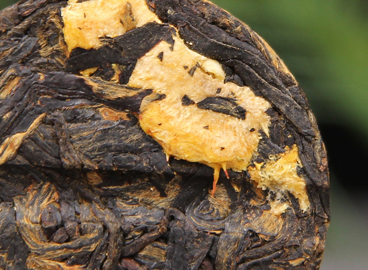 Close-up of Cili chestnut rose fruit pieces pressed into Dianhong black tea