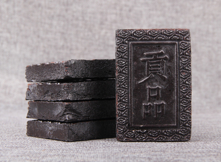 Stacked concentrated ripe Pu-erh tea paste bricks with embossed Gongpin face