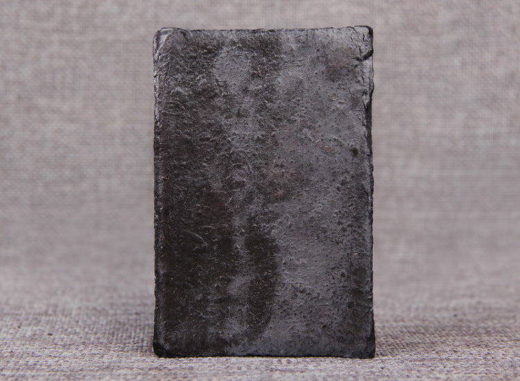 Back of 100g Pu-erh tea paste brick showing dense smooth compressed surface
