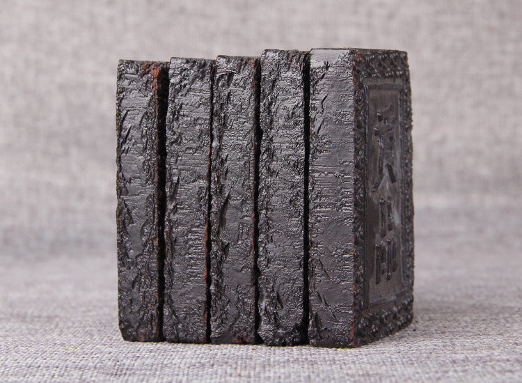 Multiple Pu-erh tea paste bricks stacked vertically for storage and display