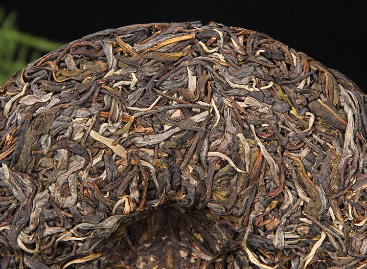 Front close-up of unwrapped 2025 Mangfei raw Pu-erh 357g tea cake