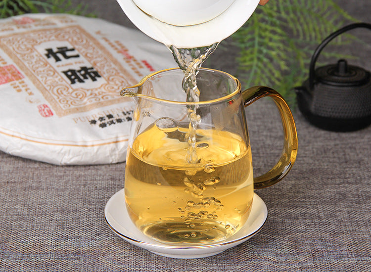 2025 Mangfei raw Pu-erh golden tea liquor being poured into a glass fairness pitcher