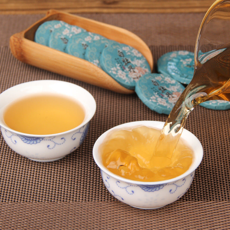 Golden tea liquor brewed from 2025 Yunnan Bai Mudan white tea mini cakes