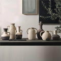 Contemporary artisan ceramic vase collection styled on a long console