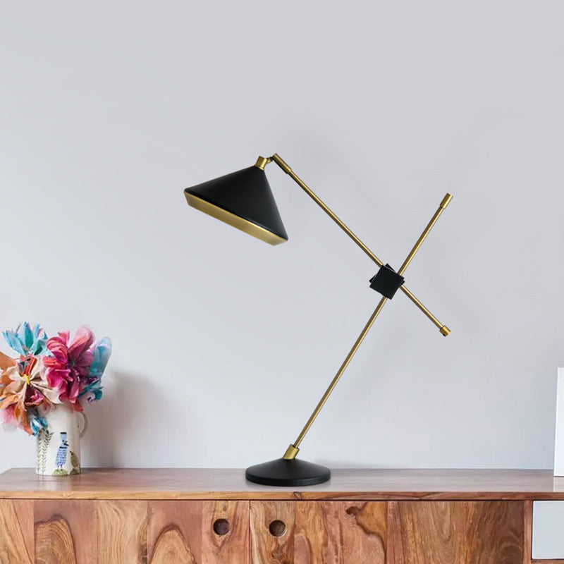 Black and antique-brass adjustable table lamp styled on a wood console