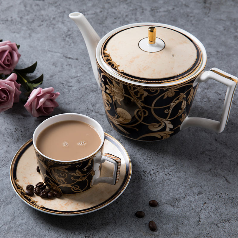 Black and gold bone china teapot with matching coffee cup and saucer in an ornate animal and botanical scroll pattern