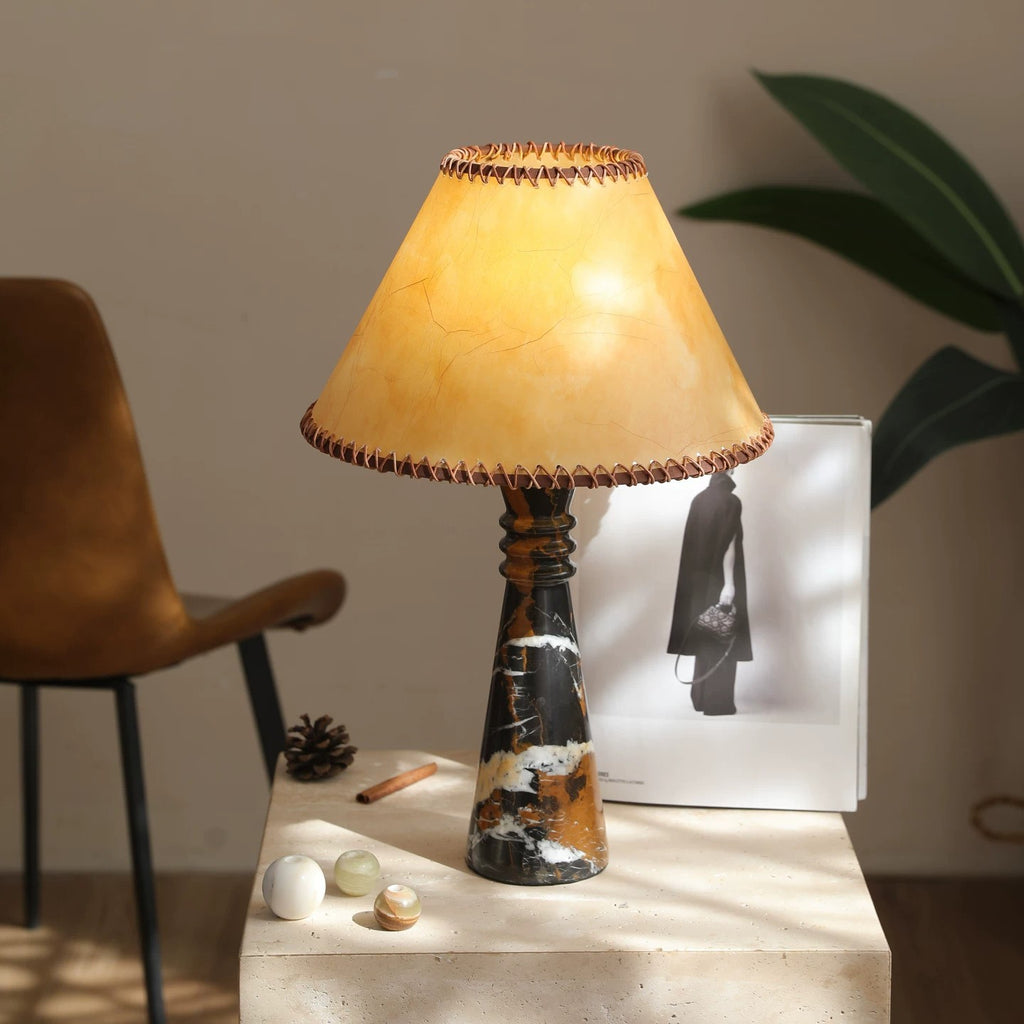 Warm black-gold marble table lamp styled with books and modern decor