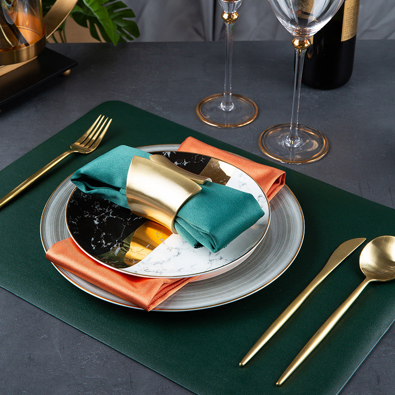 Dark green rectangular placemat paired with black white marble bone china dinnerware and gold accents