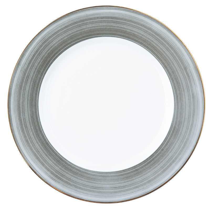 Luxury Western dining place setting with marble-pattern bone china plates, gold flatware and dark green table accessories