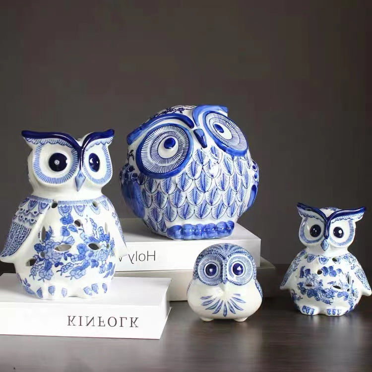 Blue and white owl figurine collection on dark wood