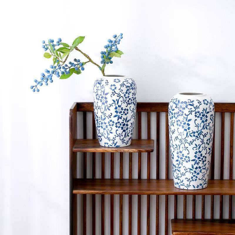 Blue and white floral cylinder vases styled together on a wood shelf