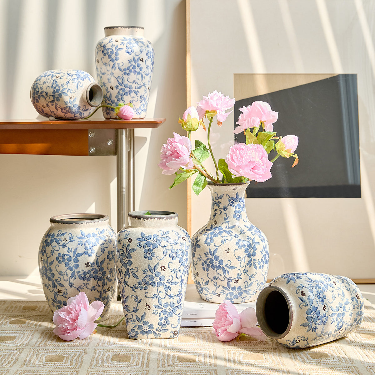 Blue and white floral vase collection styled with pink roses and dark wood