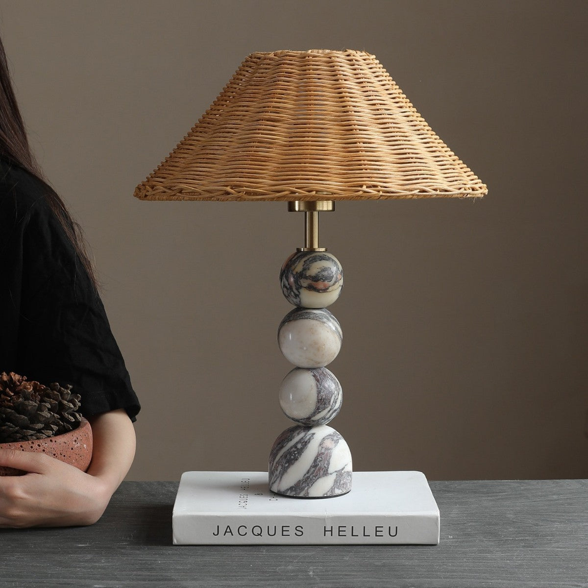 Bvlgari-vein stone sphere table lamp with natural rattan shade on a dark table