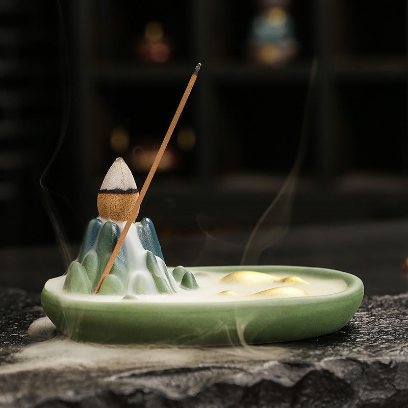 Side view of celadon bull and mountain incense holder with drifting smoke
