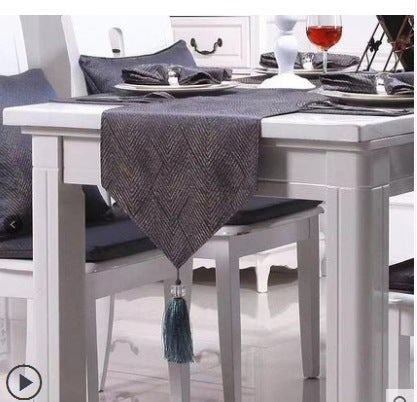 Charcoal herringbone tassel table runner styled with formal dinnerware