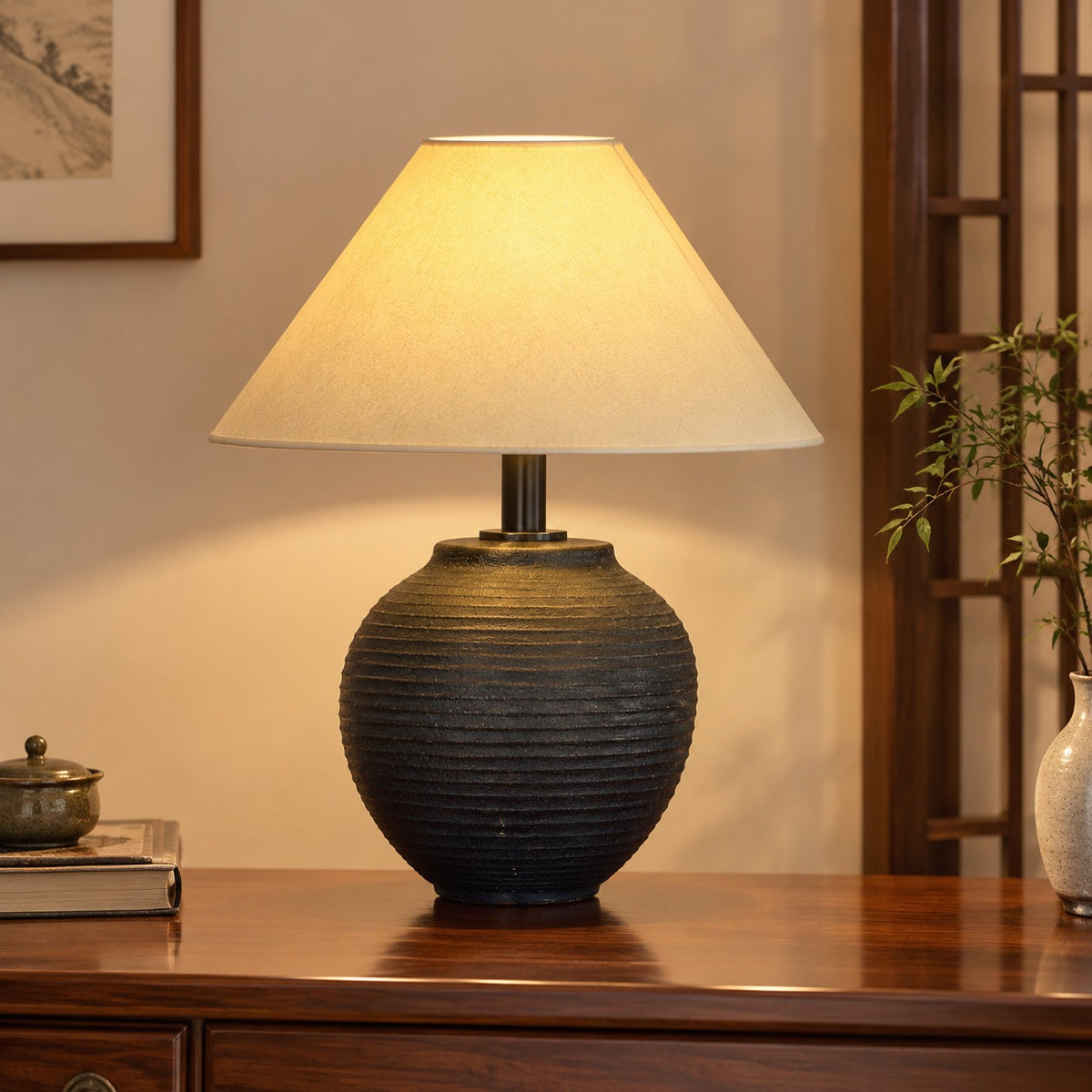 Black ribbed ceramic jar table lamp on a polished wood console