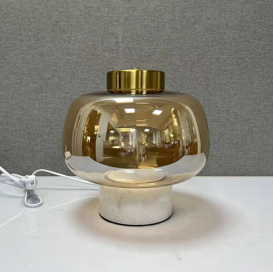 Amber glass globe table lamp with white marble base and brass top