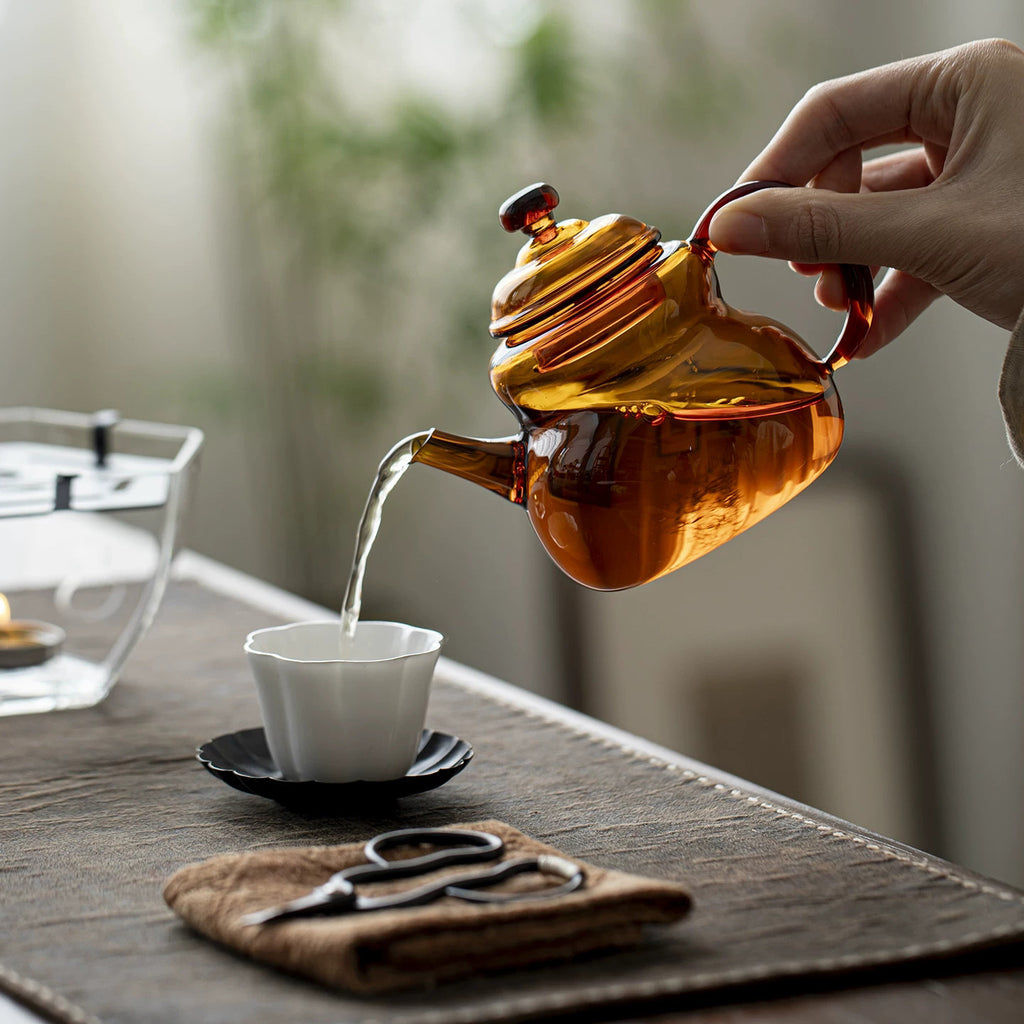 Amber glass teapot pouring Chinese loose leaf tea