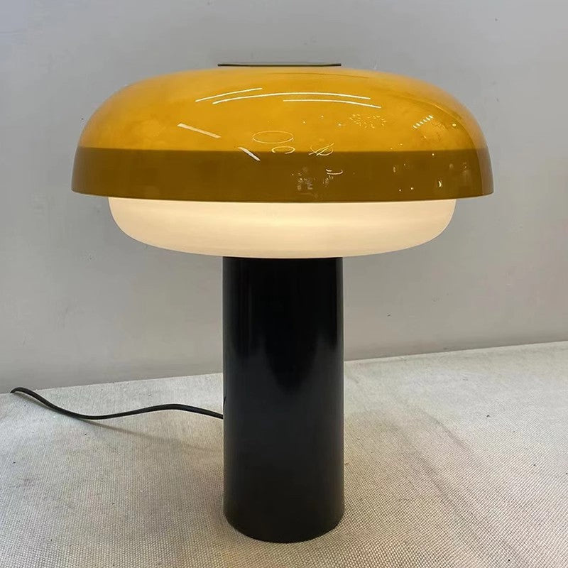 Amber glass mushroom lamp glowing warmly on white tabletop