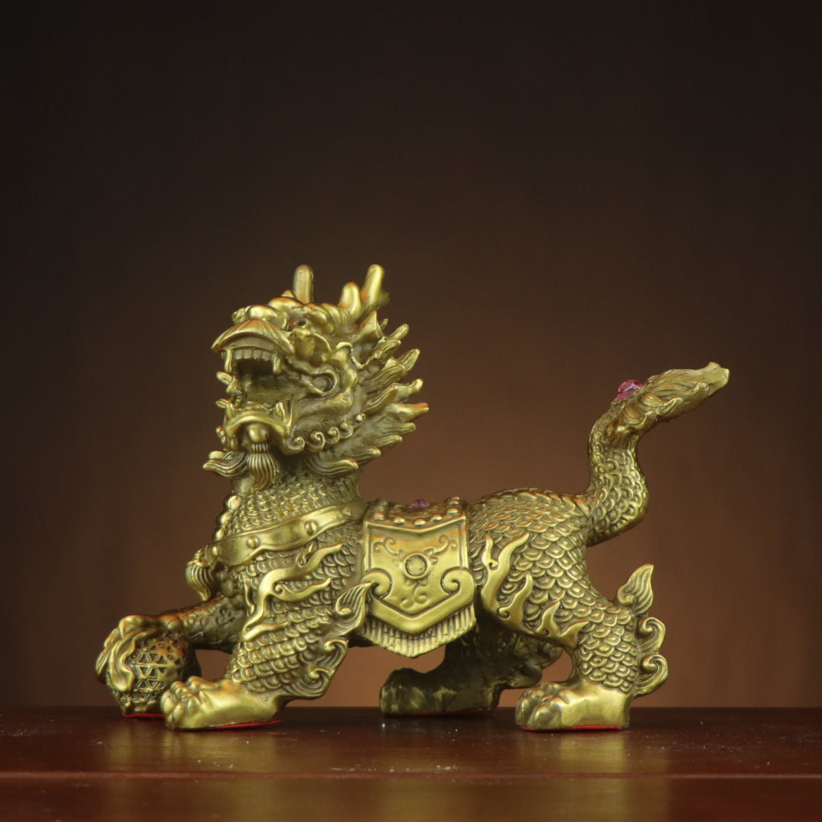Detailed Eight Treasures Qilin copperware sculpture with scaled body, auspicious orb and red accents for Chinese home office and executive decor