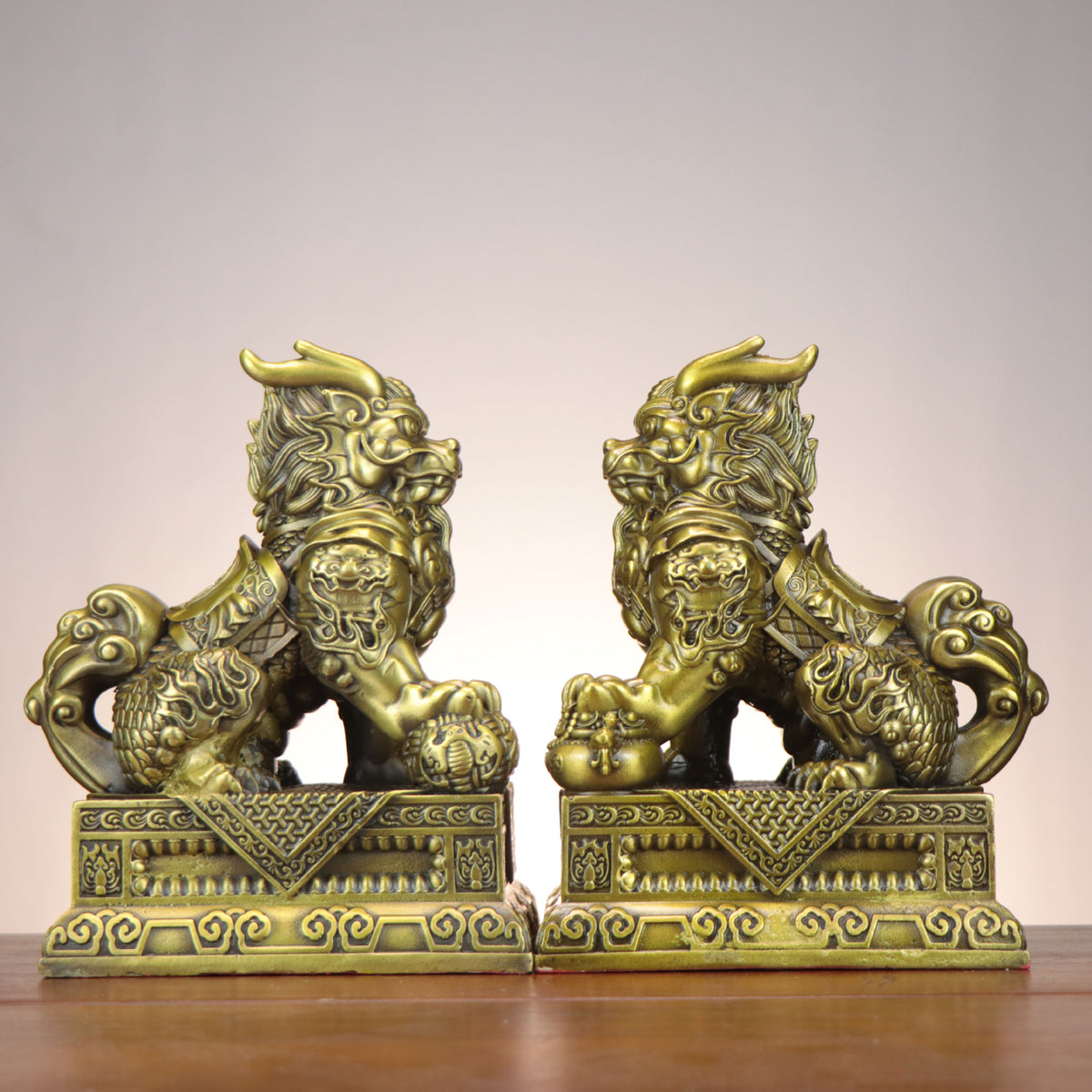 Side view of Chinese Bagua Qilin copperware pair with cloud tails, armor details, treasure bag and auspicious symbols