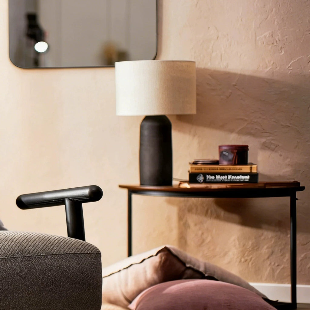 Tall black ceramic lamp on console in warm modern living room