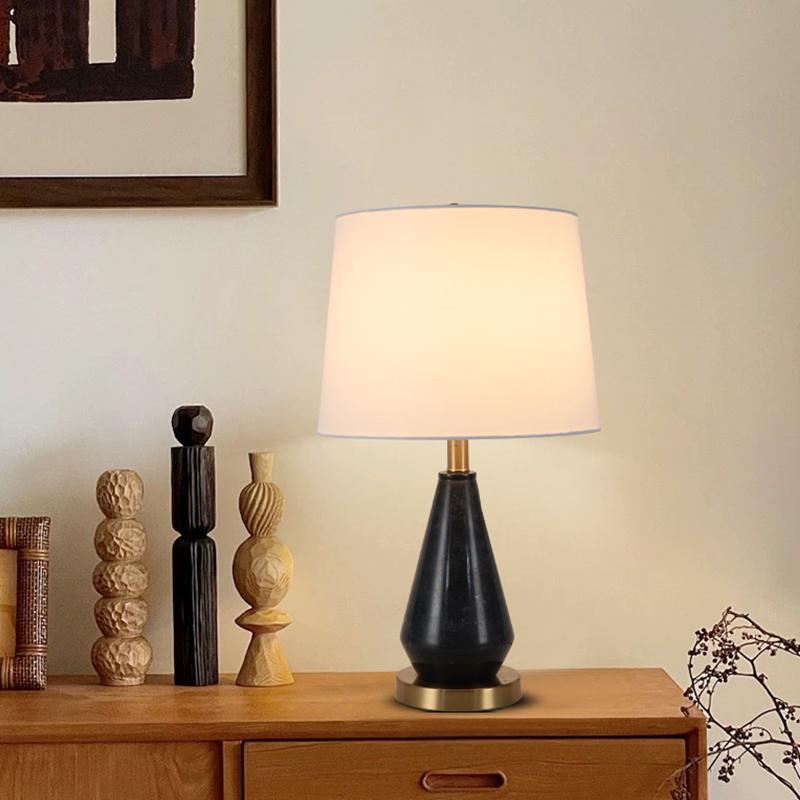 Black marble table lamp styled on warm wood sideboard