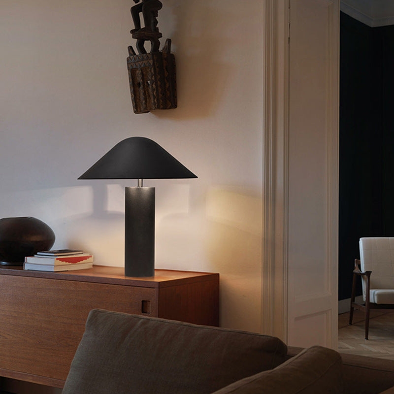 Matte black postmodern cone lamp styled on walnut sideboard