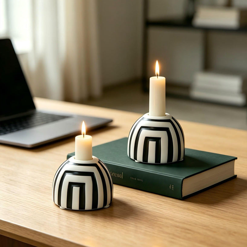 Striped ceramic candle holders with taper candles on books