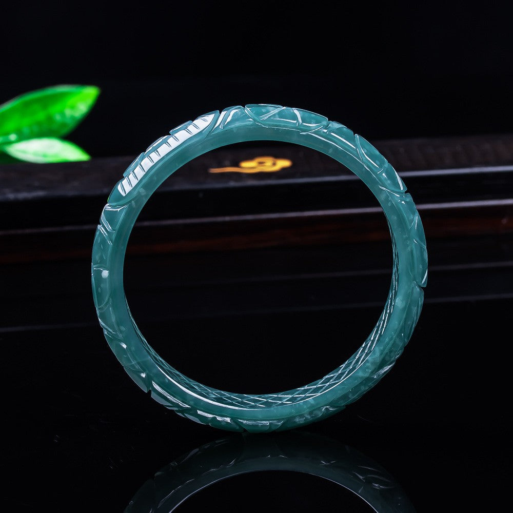 Dragon phoenix jadeite bangle showing carved scale and feather texture