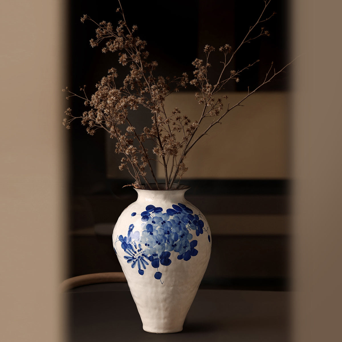 Blue botanical porcelain style vase detail with textured cream ceramic body