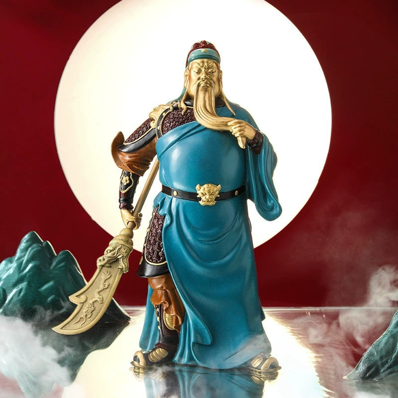 Yellow brass Guan Gong Guan Yu sculpture in blue robe with guandao against moon backdrop