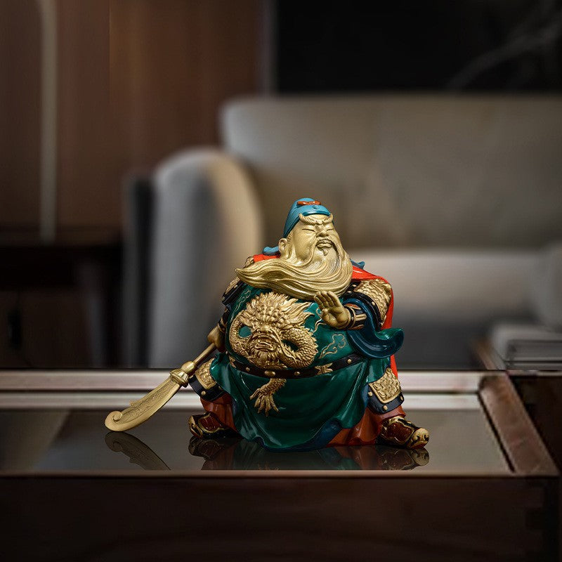 Brass Guan Gong Guan Yu martial wealth deity sculpture displayed on an office desk in a modern interior