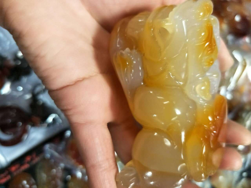 Natural chalcedony Pixiu hand piece showing sculpted face and body