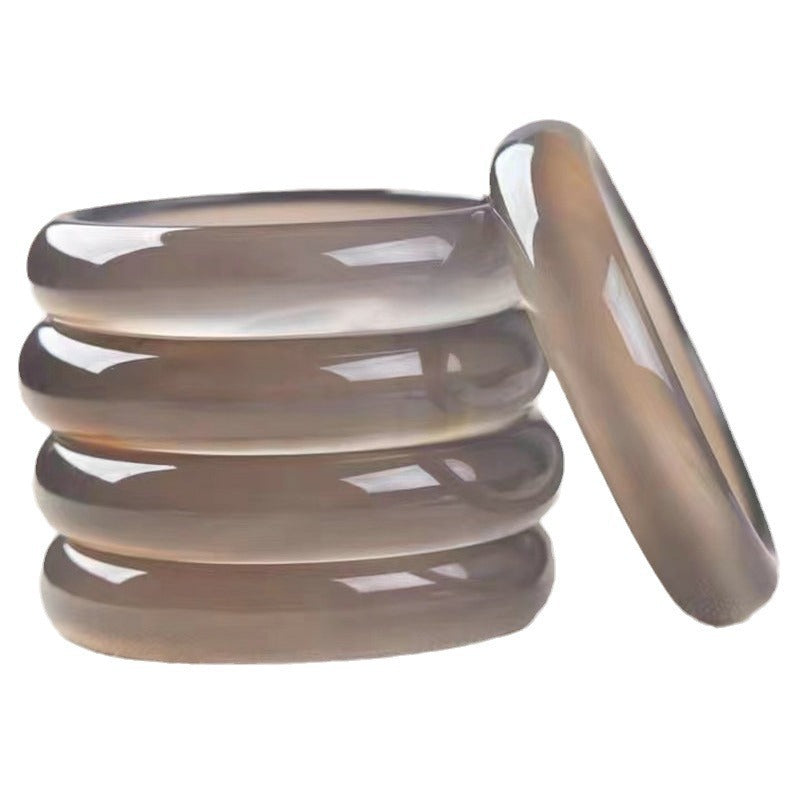 Natural smoky gray chalcedony agate bangle showing warm taupe-gray translucency