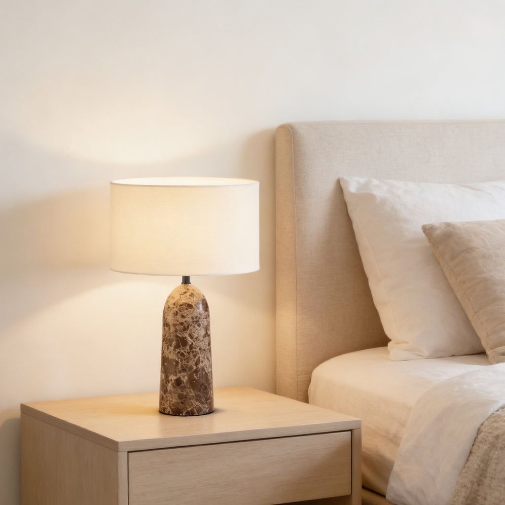 Brown marble column lamp styled on a cream bedroom nightstand