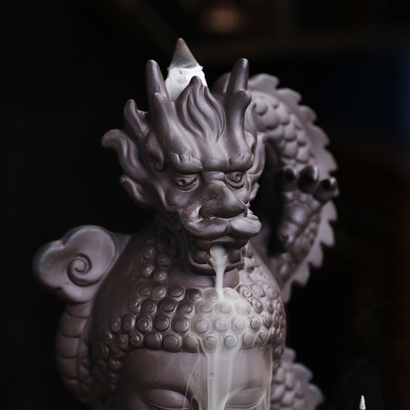 Close-up of dragon head channeling backflow incense smoke over Buddha
