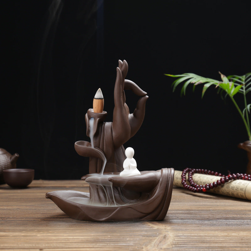 Quiet Mind monk incense burner with sculptural Buddha hand and smoke waterfall